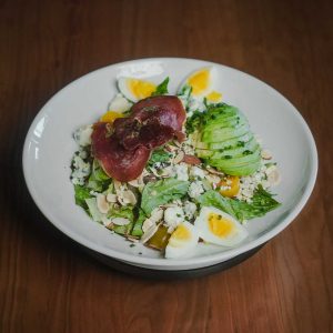 Romaine, crispy prosciutto, tomatoes, avocado, blue cheese crumble, hard boiled egg, green onions, toasted almonds